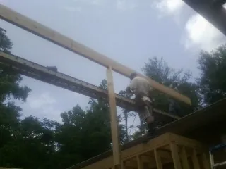 Carpenter setting a ridge beam over a new addition frame — Ice Dam Removal by Roofing Brothers in Shingle Springs